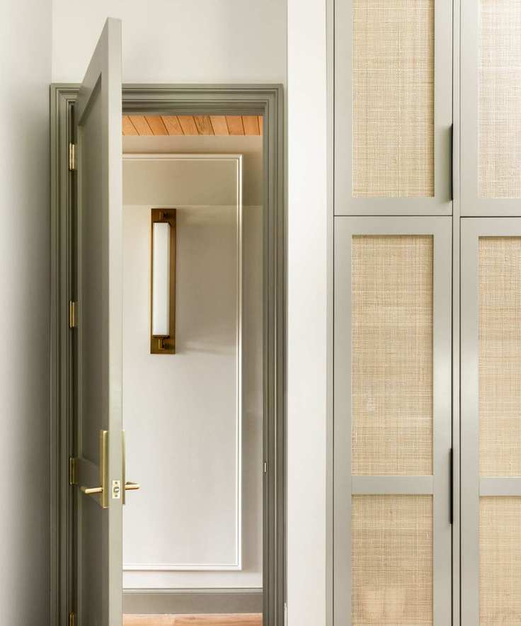 A doorway with walls painted in Modern Gray, featuring brass lighting.
