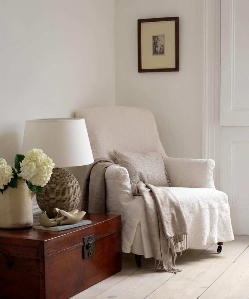 neutral living room with armchair and wooden chest