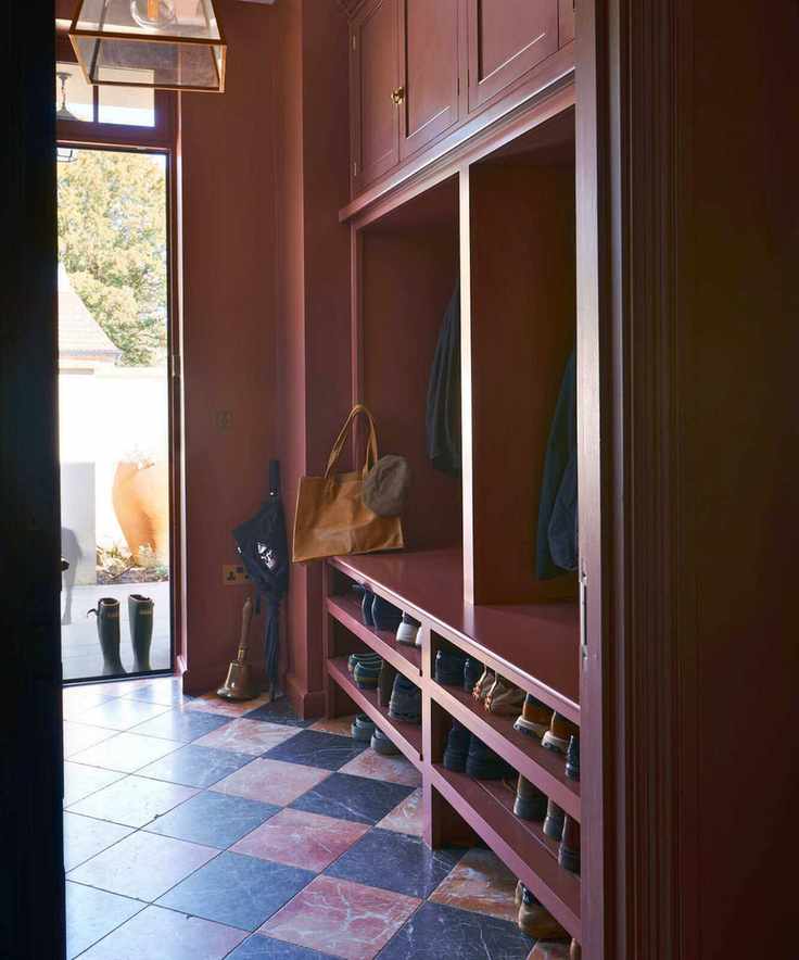 Moody burgundy boot room with marble checkered floor and built-in storage to the right