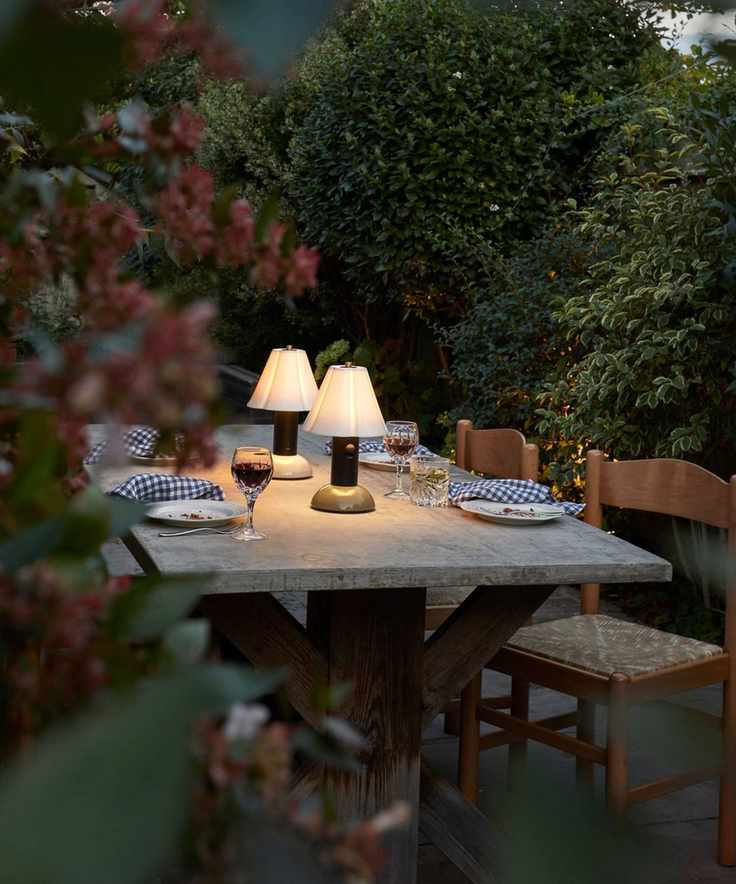 garden dining table at dusk with portable lamps