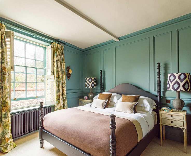 Main bedroom with blue-green paneling and floral accents