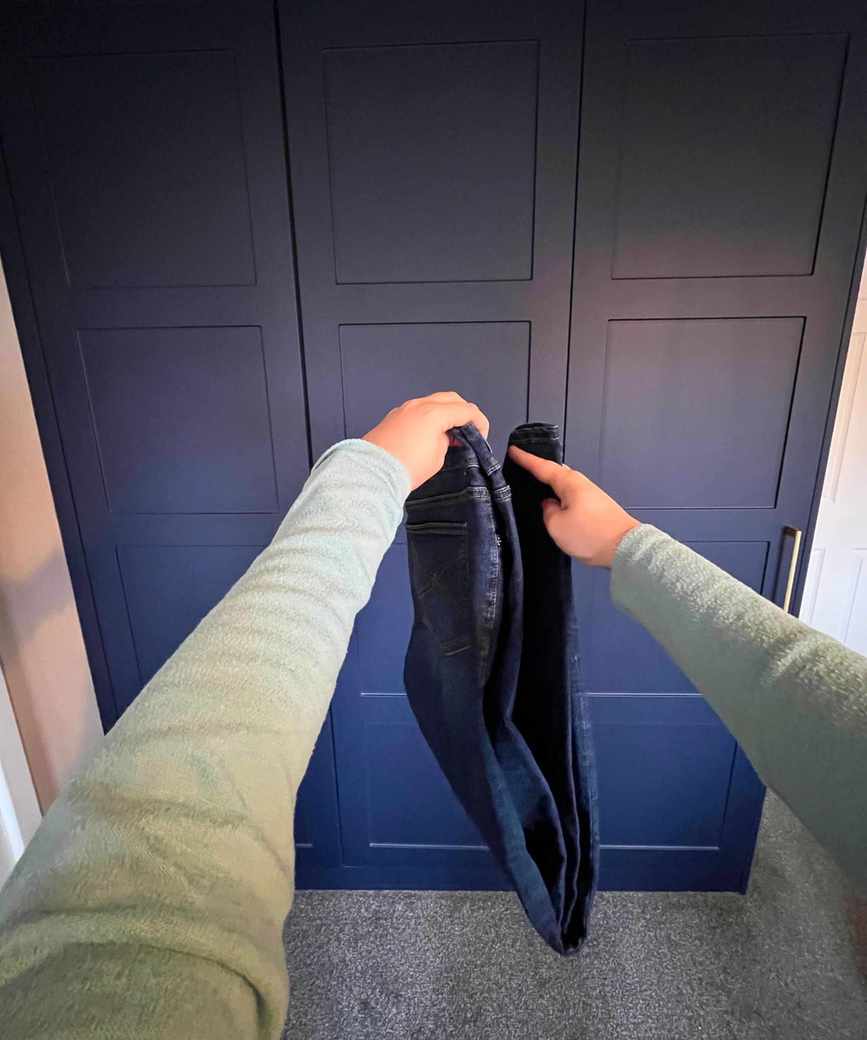Pictured is the jeans sideways with the hems brought up together to touch the waistband
