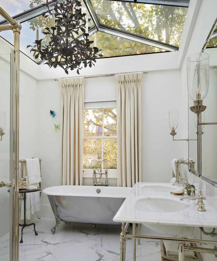 A white bathroom with black chandelier and glass ceiling
