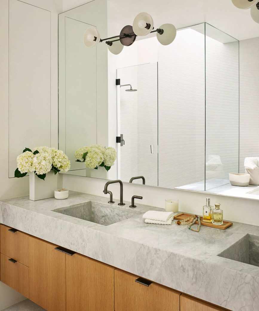 Midcentury bathroom showcasing a wooden vanity unit and large mirror