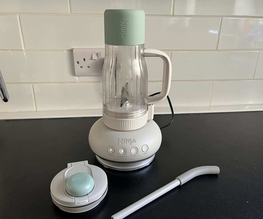 A tumbler cup forming a blender on a black counter.