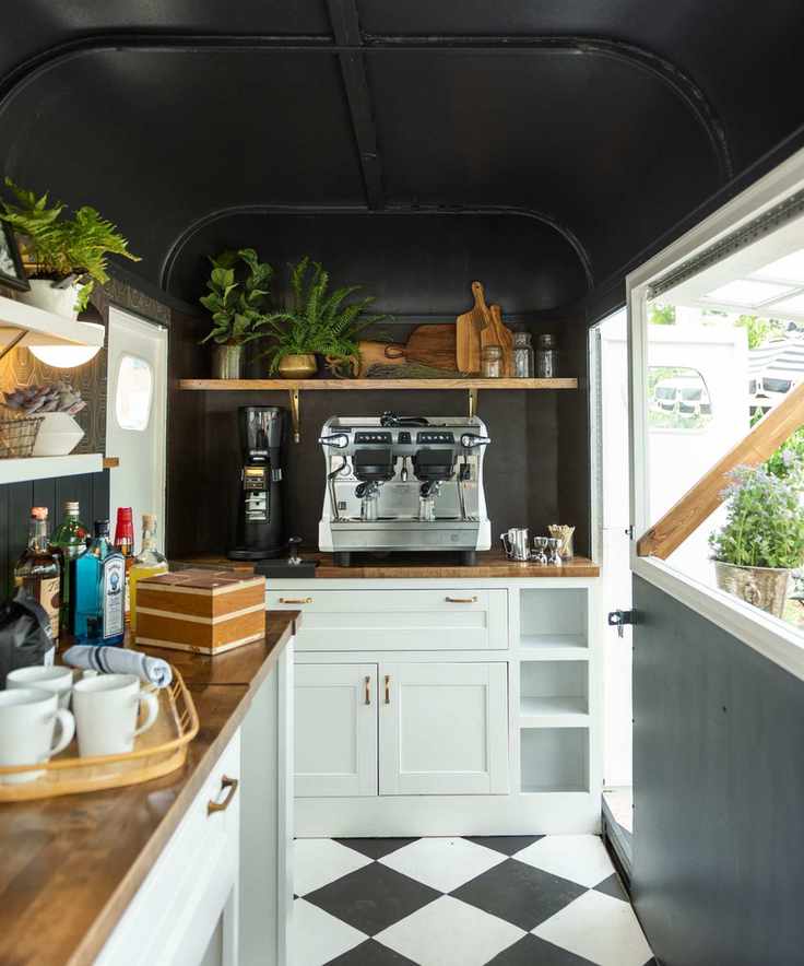 A coffee bar with checkered flooring and a large silver espresso machine.