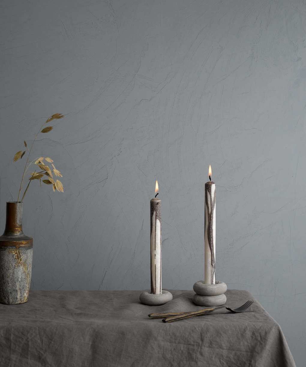 Table setting with silver gray wall and candles