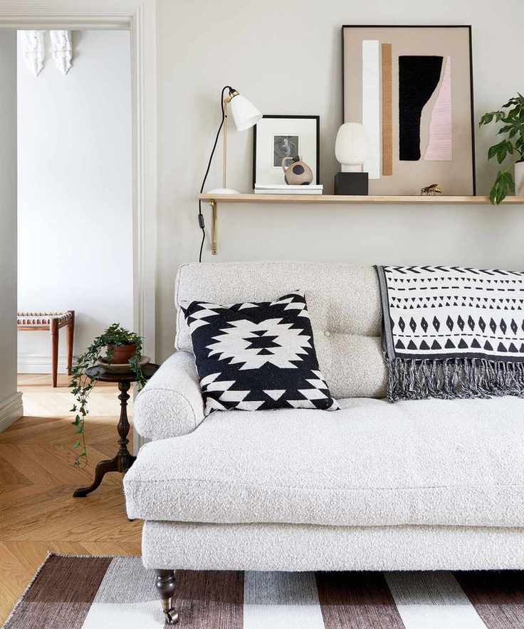 Beige living room with a roll-top sofa and monochrome art pieces.