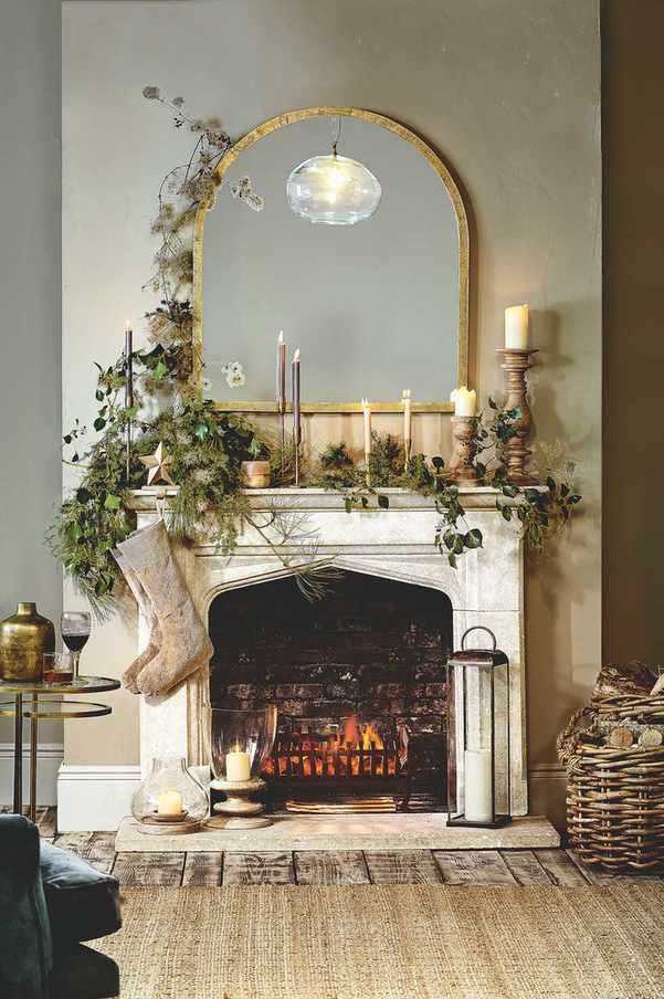 Festive mantelpiece with stockings, mirror, and greenery