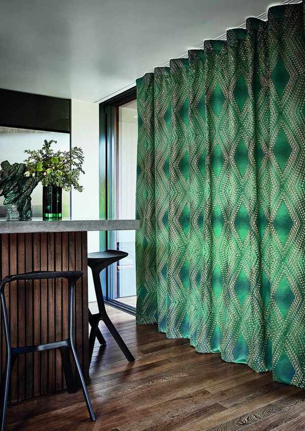 Green patterned curtains in room with bar and stools