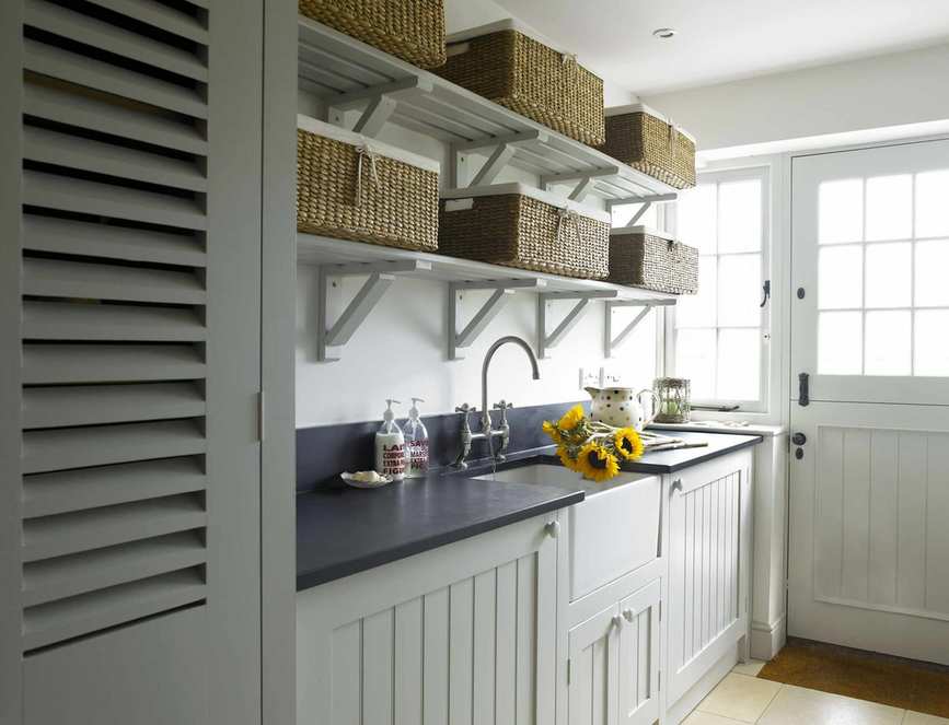 Neutral cupboards with dark tops and shelving featuring baskets