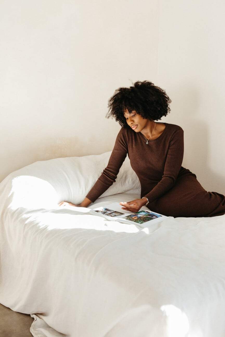 woman reading book on bed