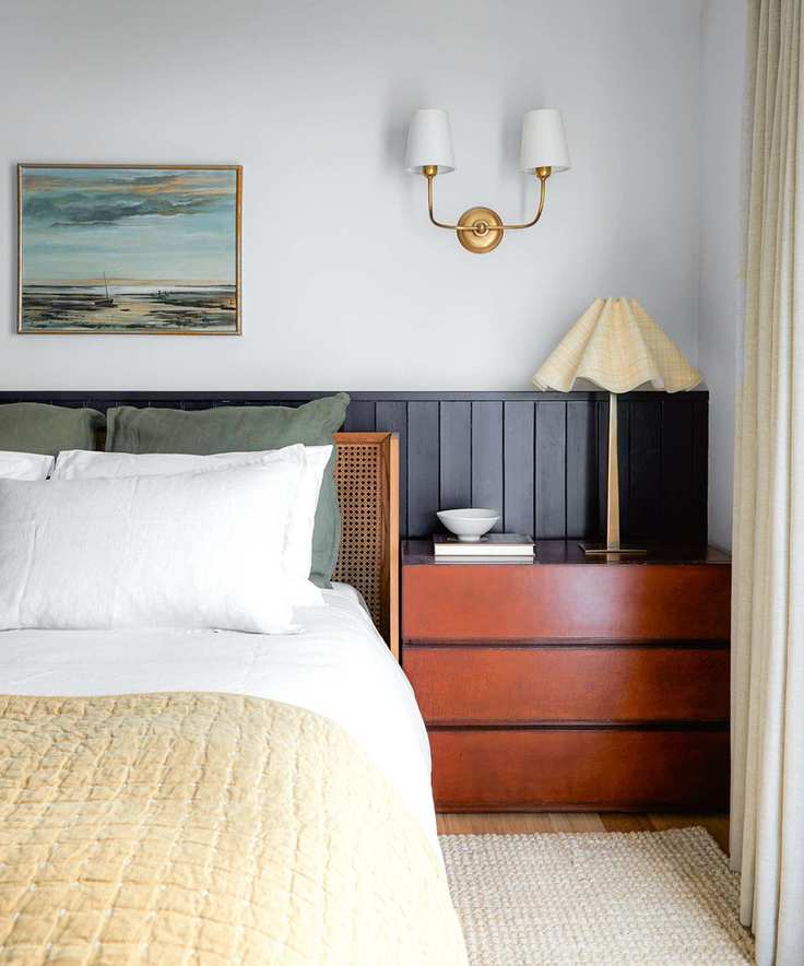 bedroom with wooden bedside unit and blue wood panelling