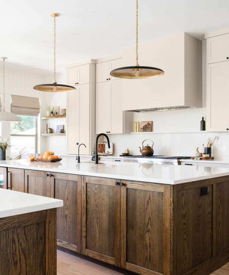 modern kitchen with wood island, white counters with neutral cabinets and brass pendant lights