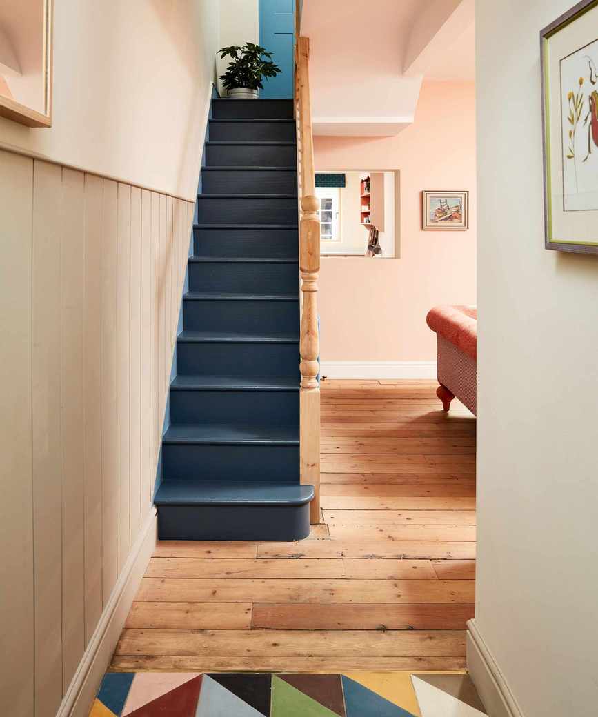 Pale pink hallway with dark blue stairs