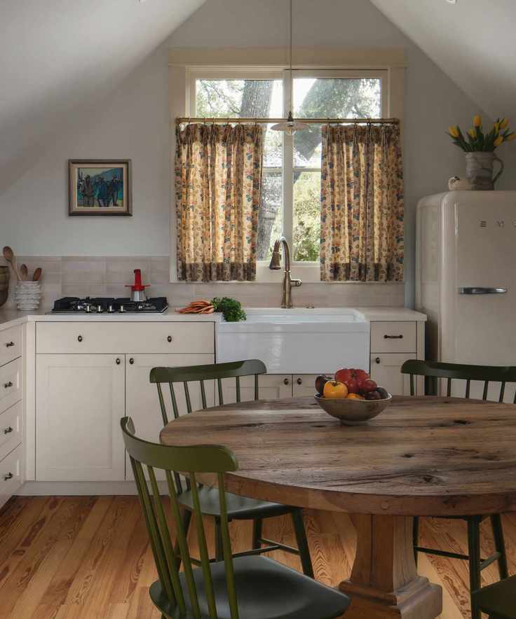 small ktichen with beige cabinetry and walls and a cute cafe curtain