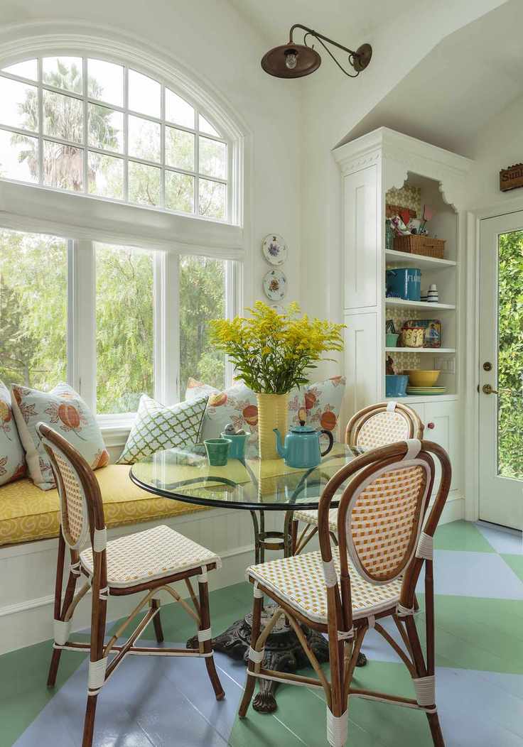 country kitchen diner with banquette seating and dining table with wicker chairs