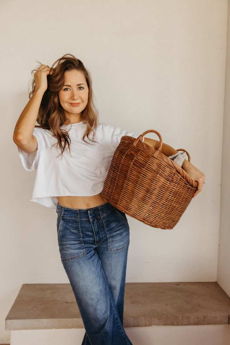 Person carrying laundry basket while practicing healthy weekend habits.