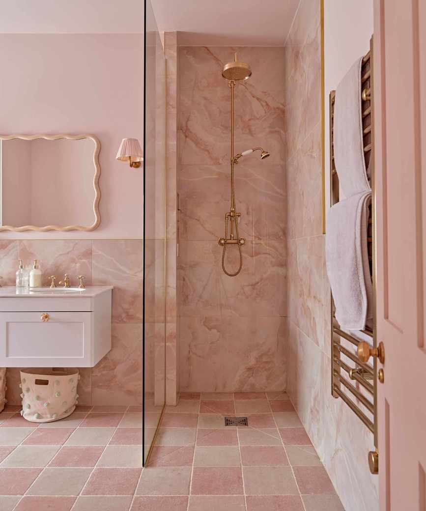 A pink guest bathroom with gold hardware