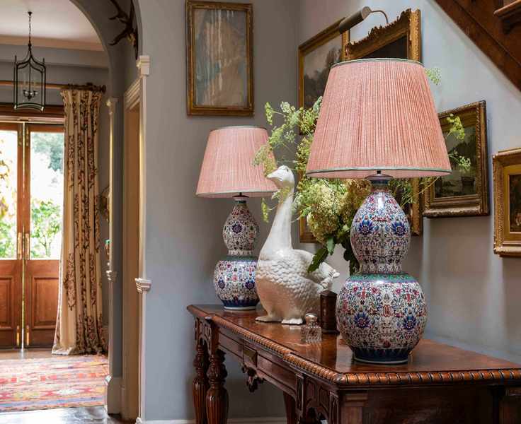 hallway showing console table with matching lamps and front door with curtain