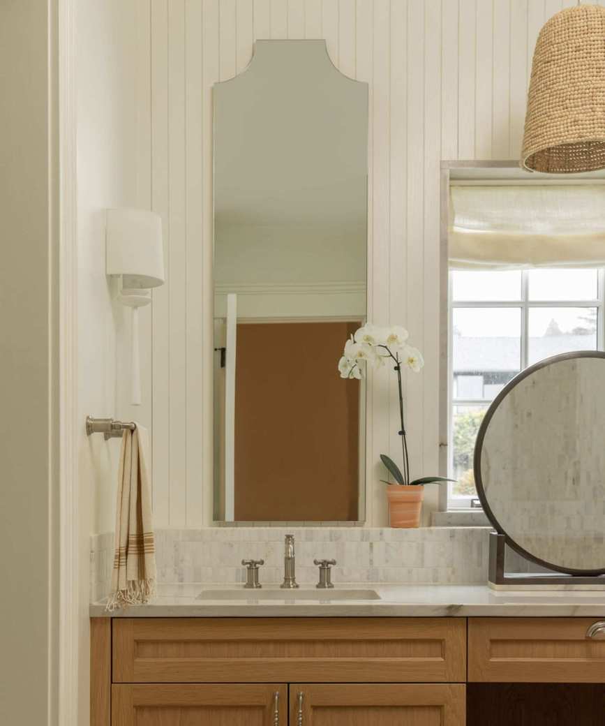 A warm neutral guest bathroom with wall paneling