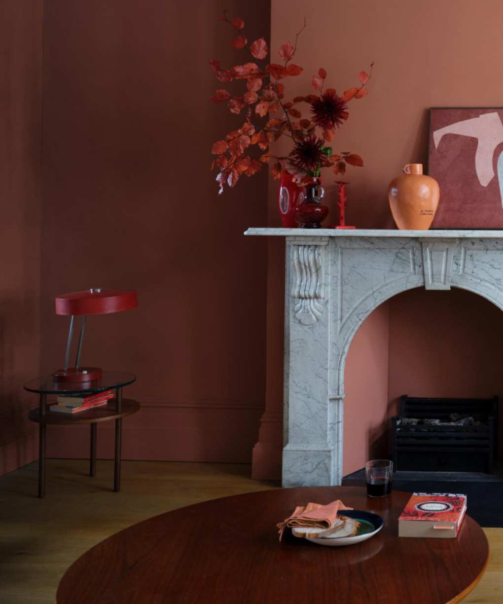 terracotta / coral living room with marble fire surround, coffee table, vase, artwork, side table
