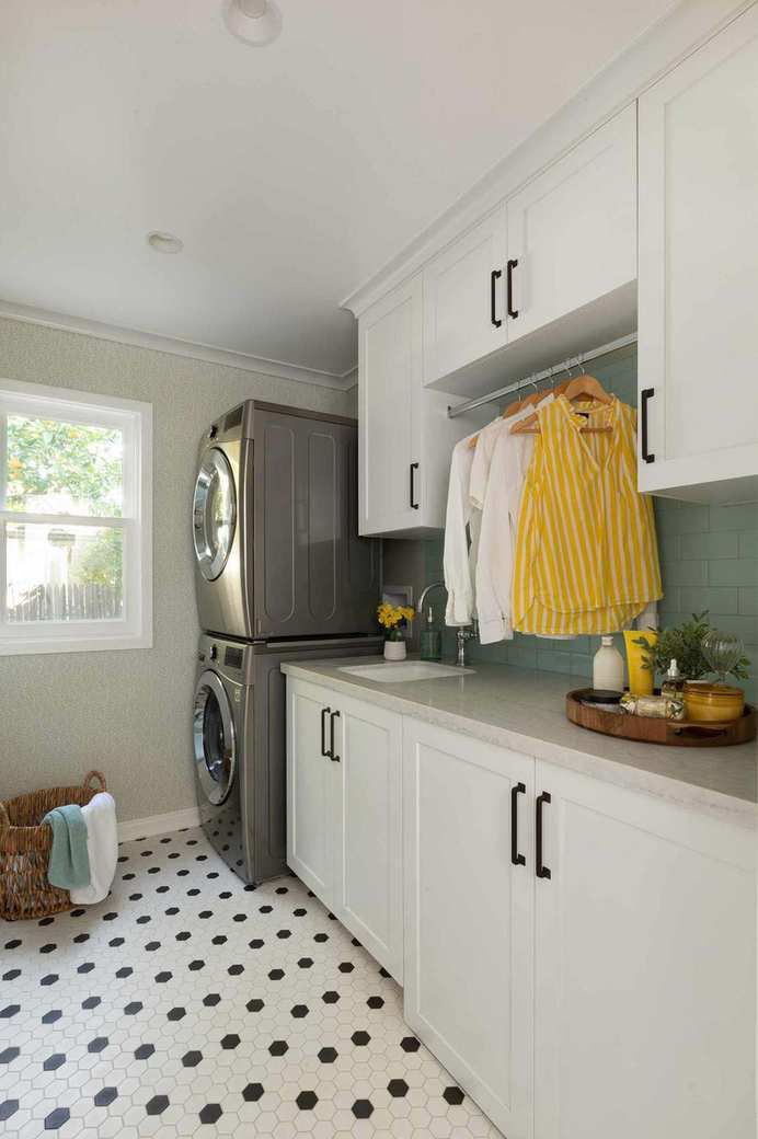 laundry room with hex tiles and stacked appliances