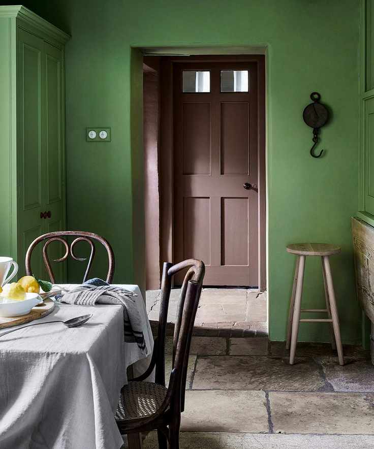 Traditional dining area painted in vibrant green with classic features