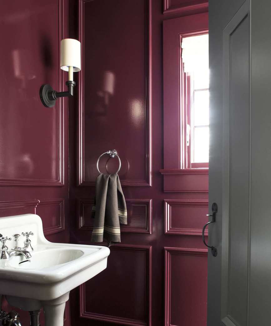 A powder room painted in deep burgundy