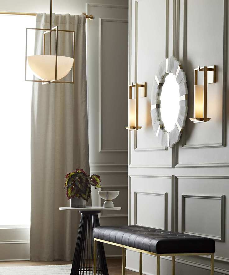 A hallway lighting idea featuring gold ceiling pendant and sconces