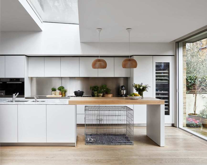 A contemporary white kitchen featuring a brushed stainless steel backsplash.