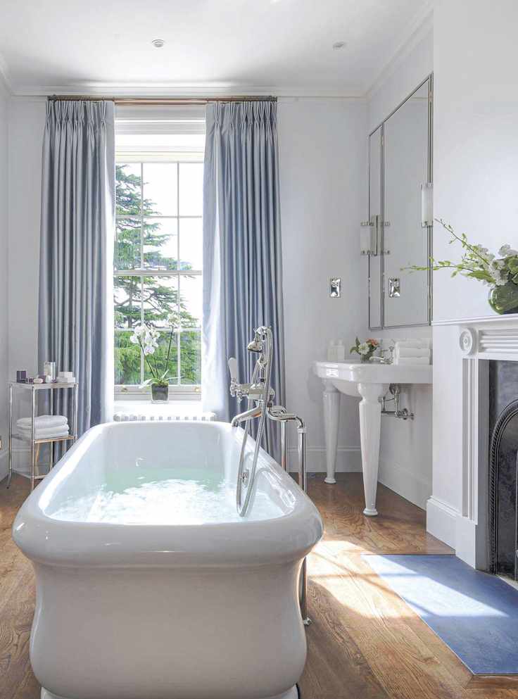 Luxury bathroom with freestanding tub and wood floor with fireplace