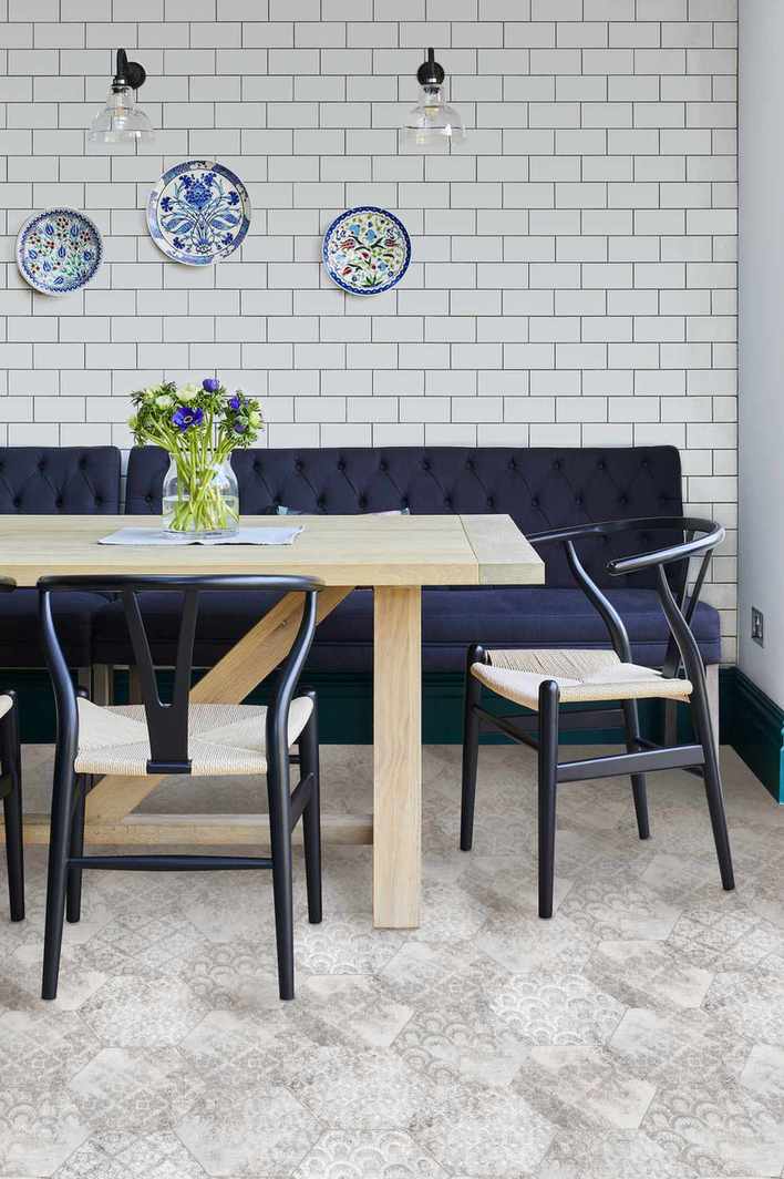 country kitchen diner with tiled wall, wooden table and blue chairs