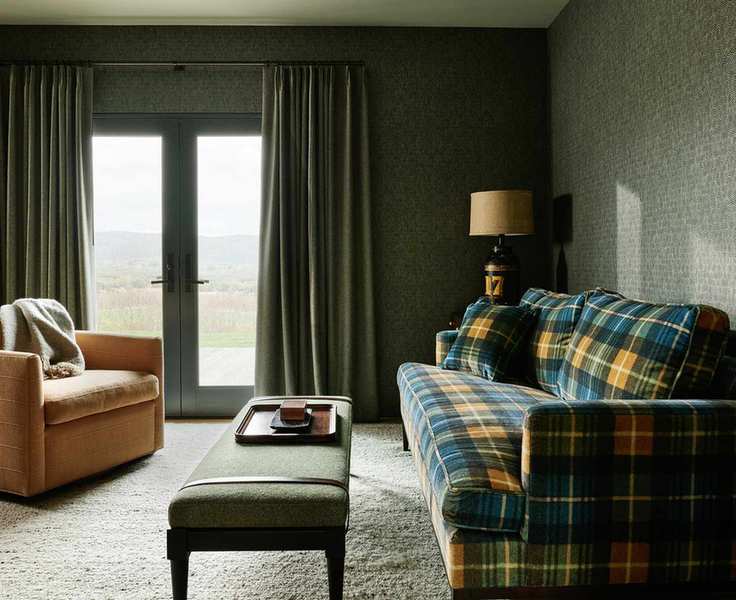 calm living room with plaid sofa and brown armchair