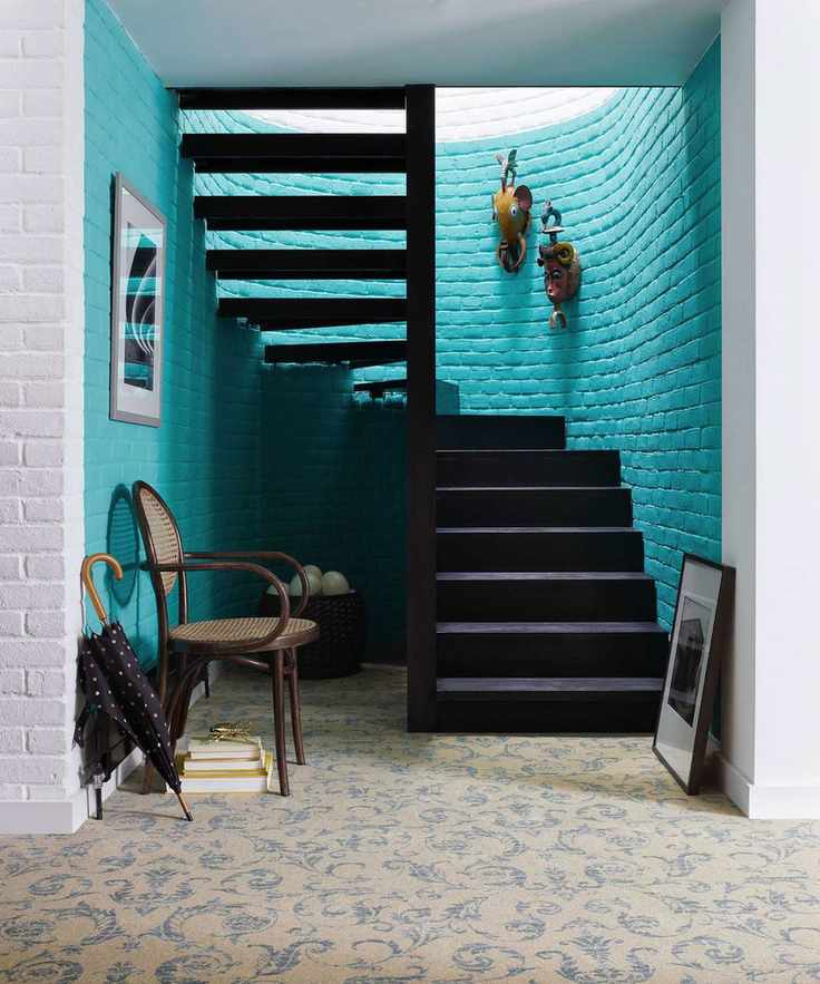 Unique hallway featuring blue accents and a patterned carpet