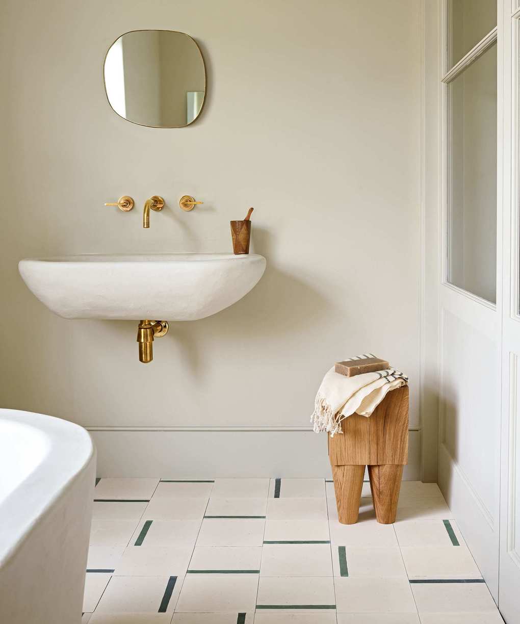 neutral bathroom with patterned tiles and wooden stool