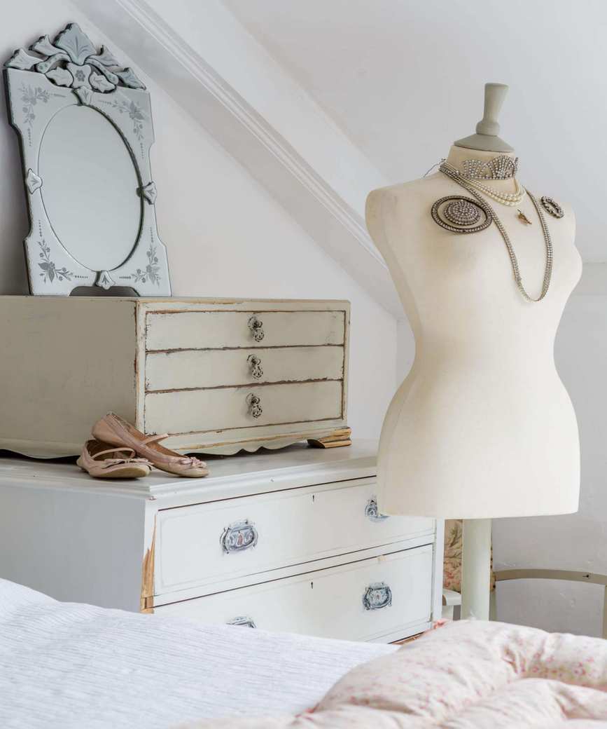 Bedroom with bed, chest of drawers and mannequin with jewelry
