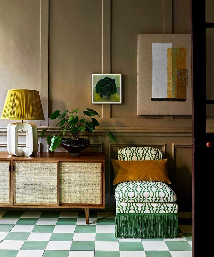 hall with green checkerboard tiled floor, sideboard and green upholstered chair