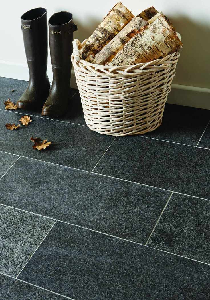 Close up of dark granite floor in a hallway with boots and log basket