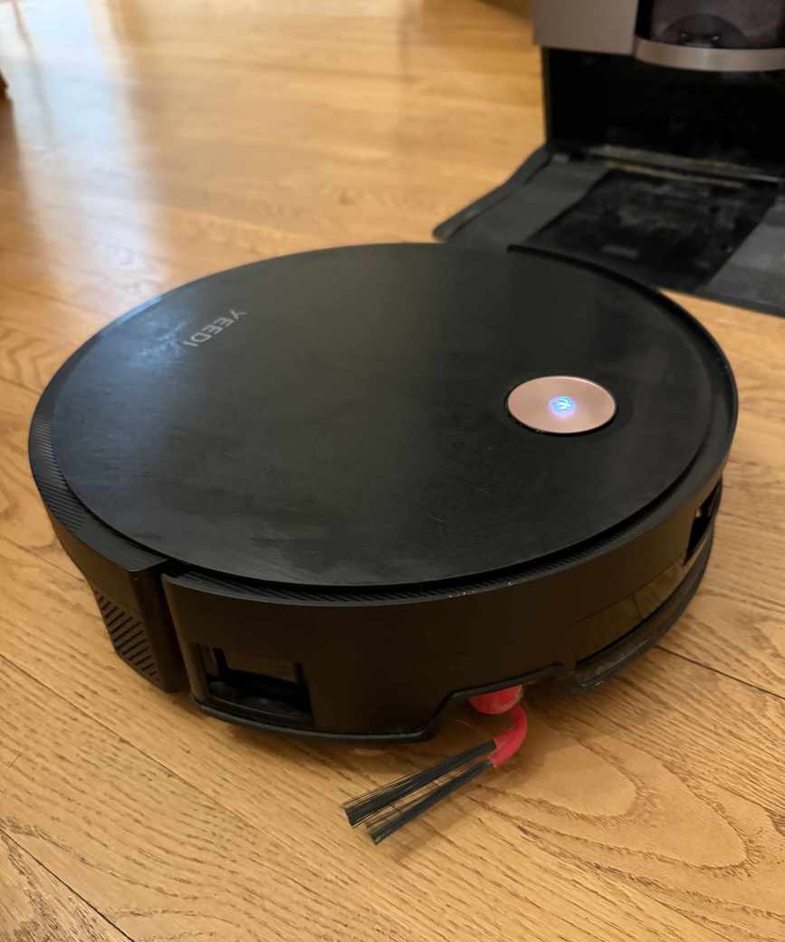 The Yeedi S20 Infinity with side brush visible and base station in background