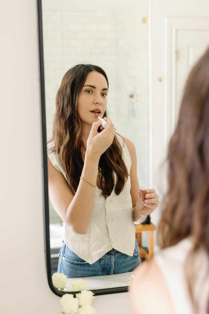 woman putting on lipstick