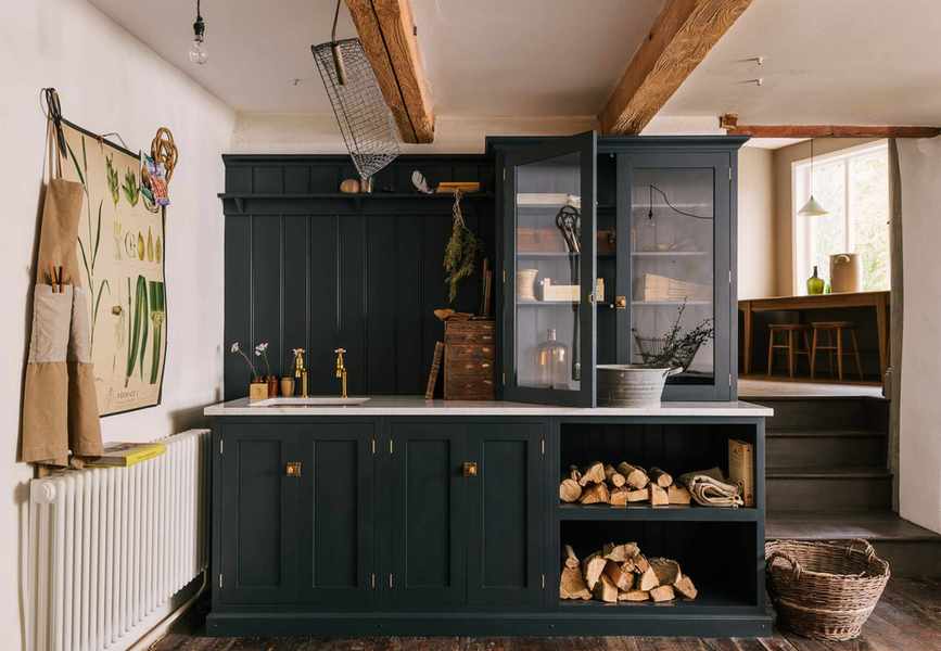laundry room with dark painted cabinetry, log store, cupboards