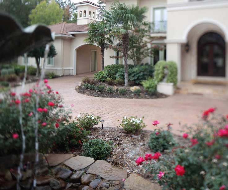 A front driveway with planting beds filled with flowers