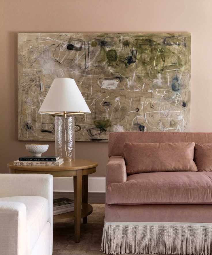 A traditional living room featuring a dusky pink sofa and muted pink walls.