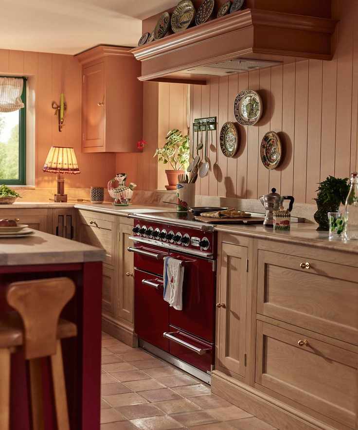 A pink kitchen with wood cabinets