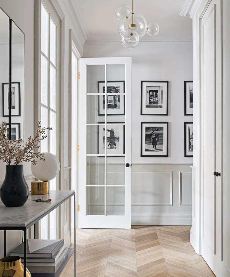 minimalist hallway with black and white photographs and parquet flooring