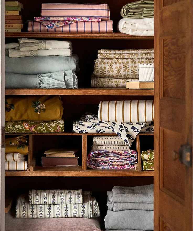 linen closet filled with folded printed bedding with florals and striped