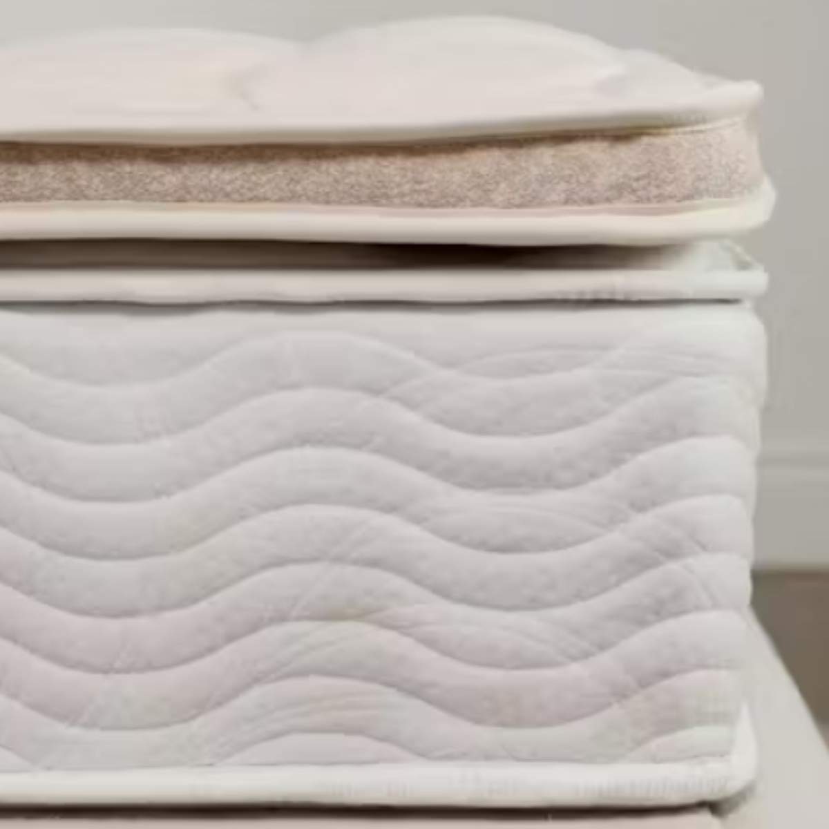 Corner of the Saatva Organic Quilted Mattress Topper.
