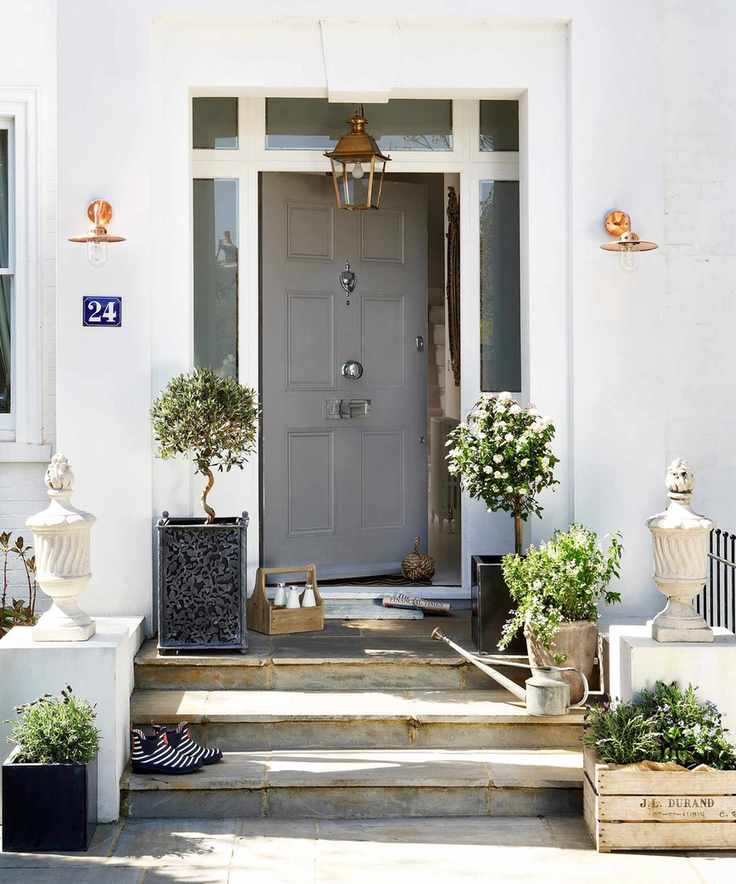 A light grey painted front door set into a white painted home.