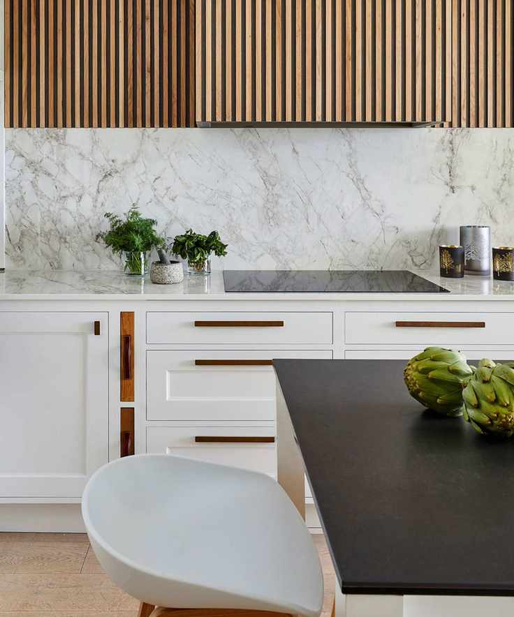 White kitchen with wood cabinets and marble backsplash